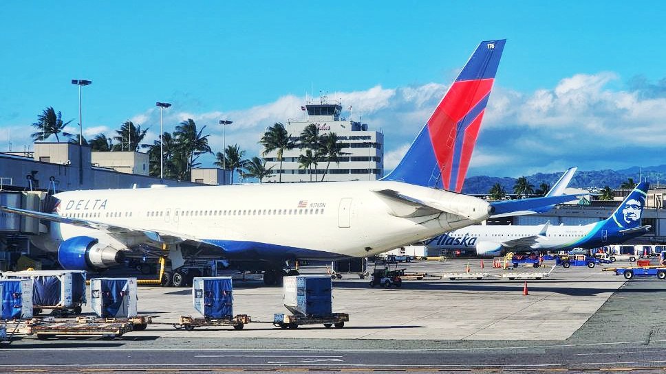 Delta Air Lines in Honolulu with Alaska Airlines hovering.